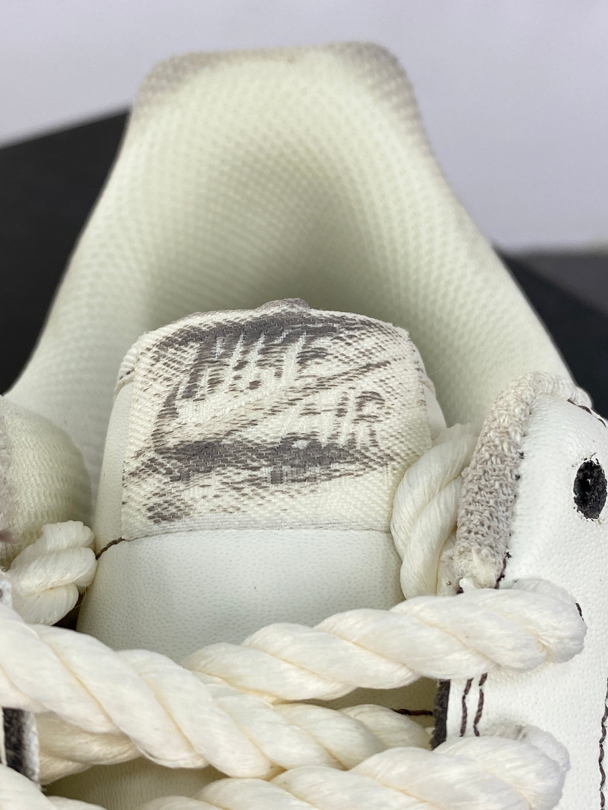 Cream low-top sneakers with rope laces and dark contrast stitching